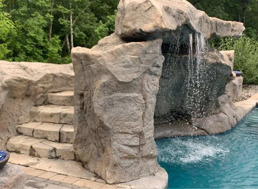 Stone pool feature jumping platform with waterfall